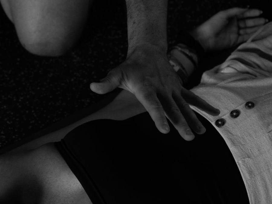 Close up of a hand guiding the breath at the belly