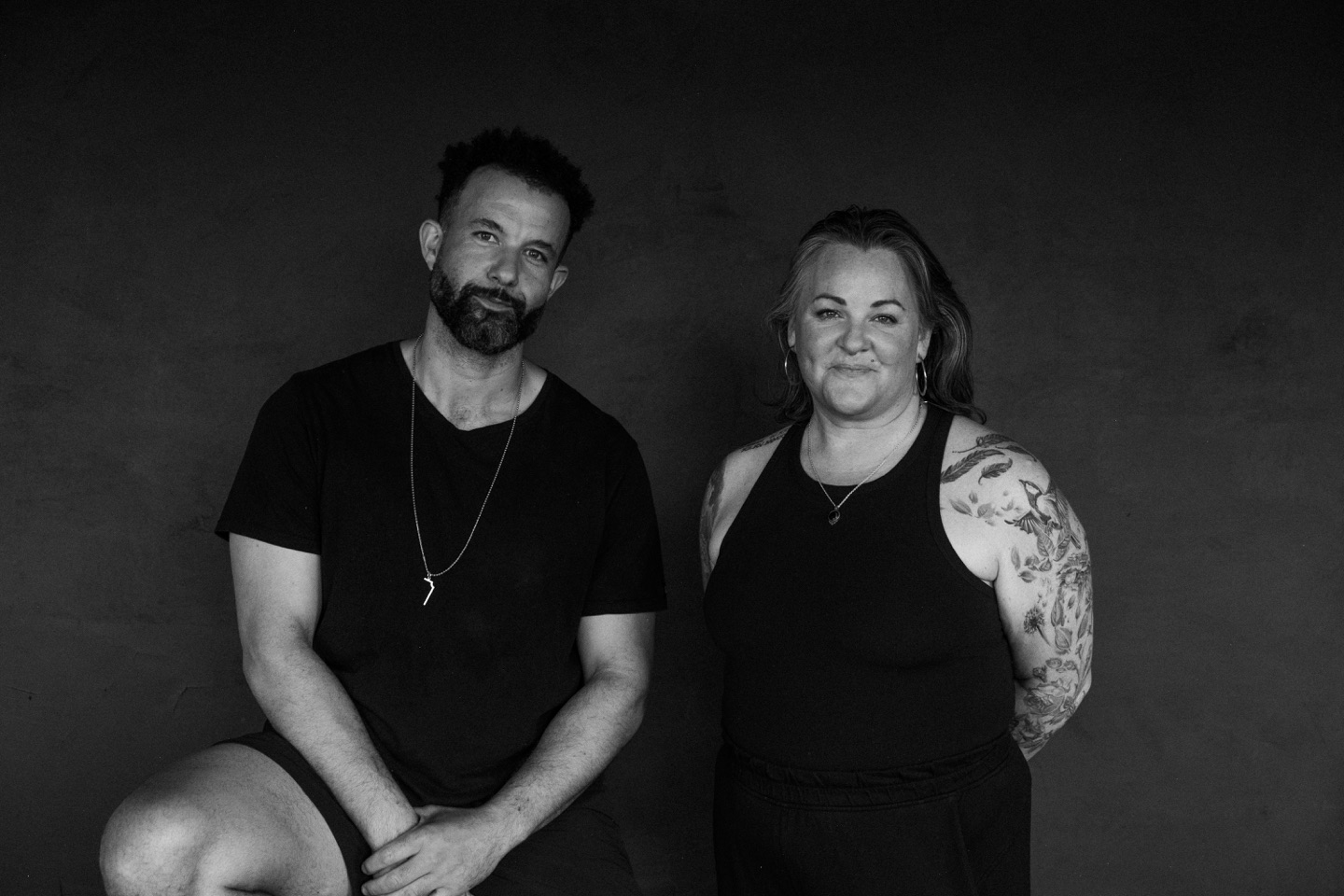 Black-and-white portrait of Tarik Hassan and Susan Benoit, co-founders of State Shift Studios, seated side by side