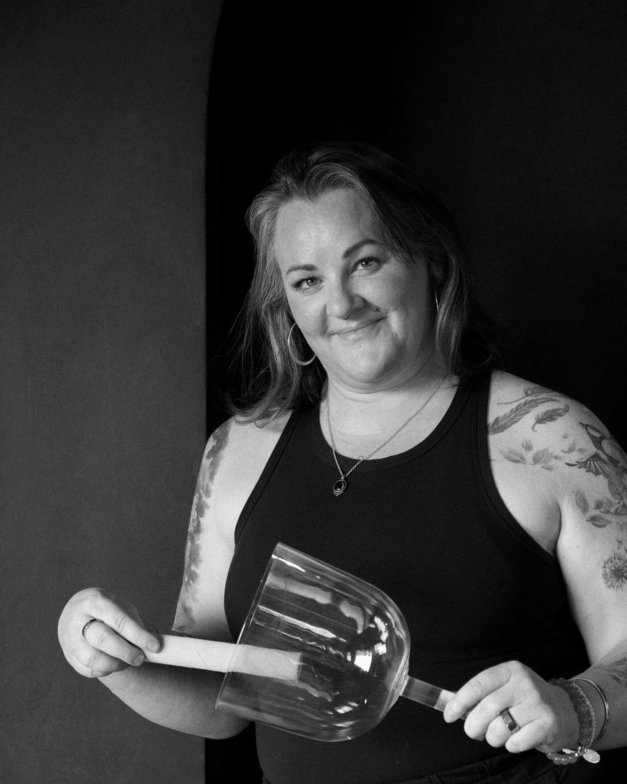 Susan Benoit, co-founder of State Shift Studios, holding a crystal singing bowl