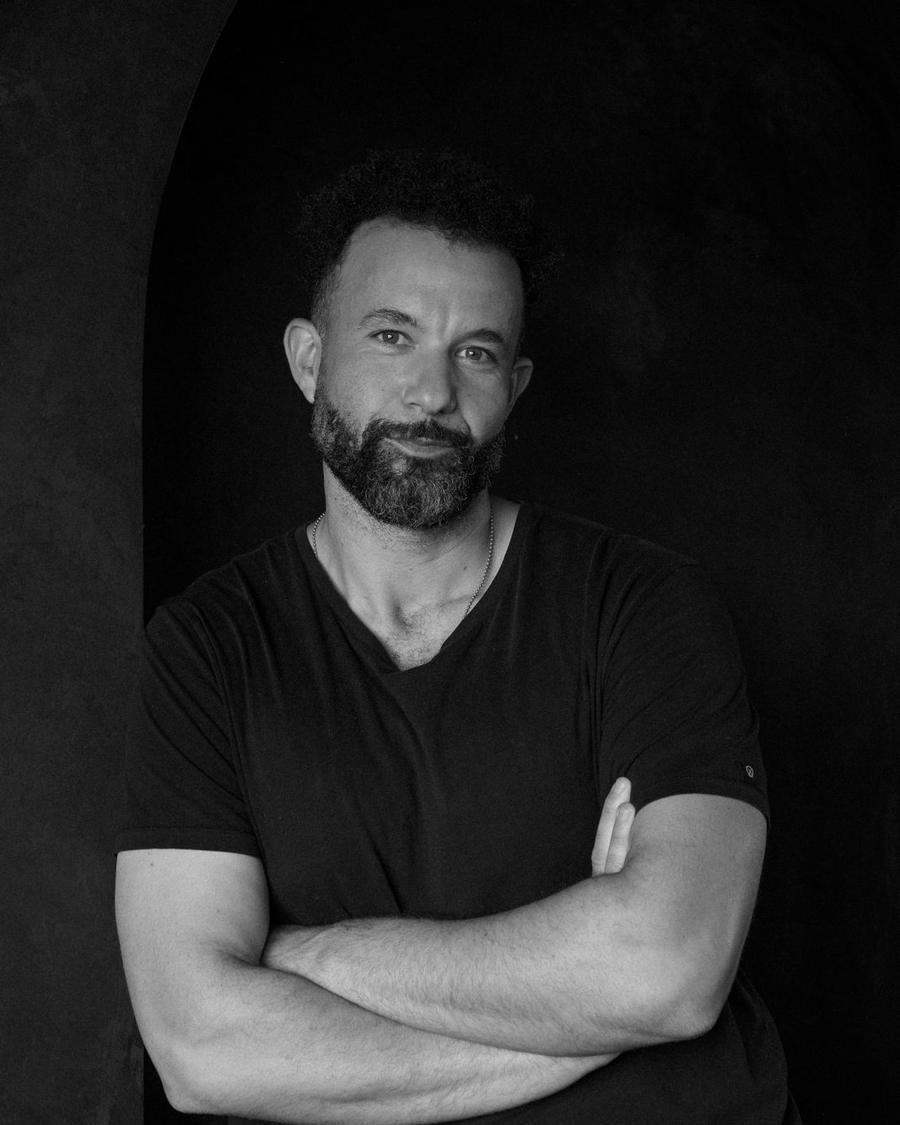 Tarik Hassan, co-founder of State Shift Studios, arms crossed, in a black tee