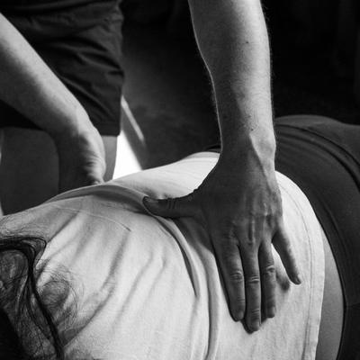 A participant with one hand on their chest and one hand on their belly, tracking breath mechanics