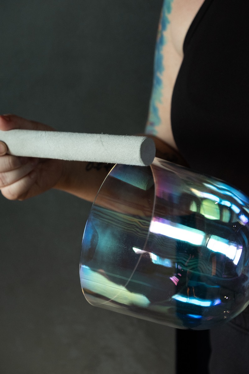 Close-up of a crystal singing bowl being played during a State Shift session