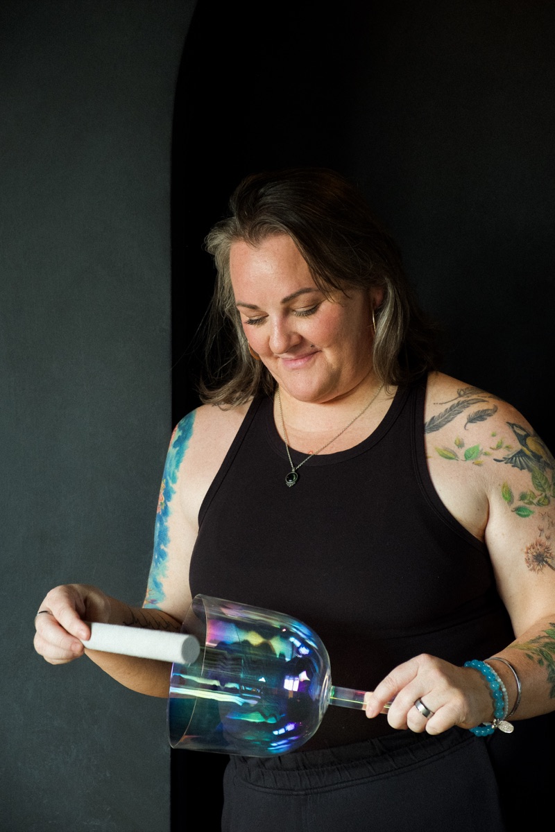 Susan Benoit, co-founder of State Shift Studios, holding a crystal singing bowl